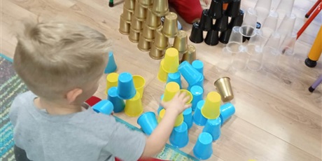 Powiększ grafikę: dzieci układają wieże z kubeczków